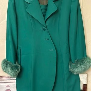 Green three-quarter length jacket and skirt, satin trimmed fur around sleeve